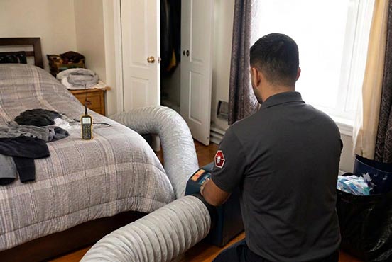 Swift-X technician setting up a portable bed bug heat treatment unit in a Toronto bedroom