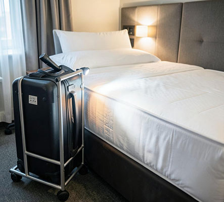 How to check a hotel room for bed bugs: luggage on a rack away from the bed